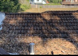 An example of a tile roof installed by a roofing contractor in Aptos Ca that has been left to collect debris causing roof failure